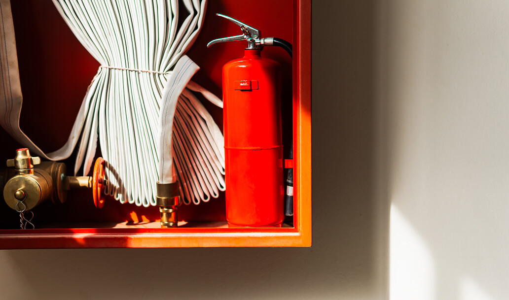 Red fire extinguisher and hose inside orange cabin